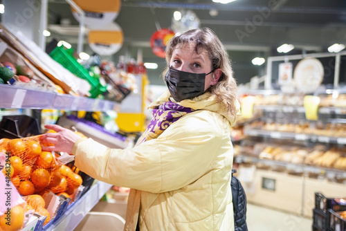 Woman in protective mask  choosing groceries in supermarket