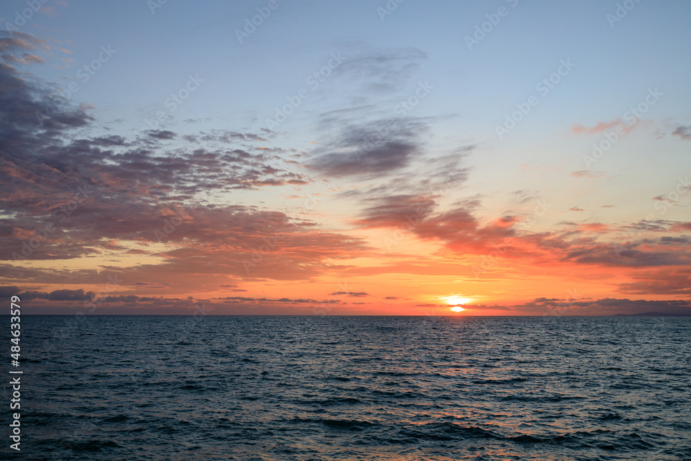evening at sea, setting sun and clouds in the sky