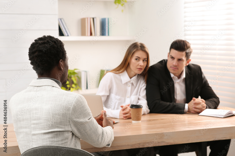 Coworkers conducting job interview with African American man in office. Racism concept Coworkers conducting job interview with African American man in office. Racism concept