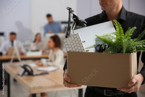 Foto Dismissed man carrying box with stuff in office, closeup