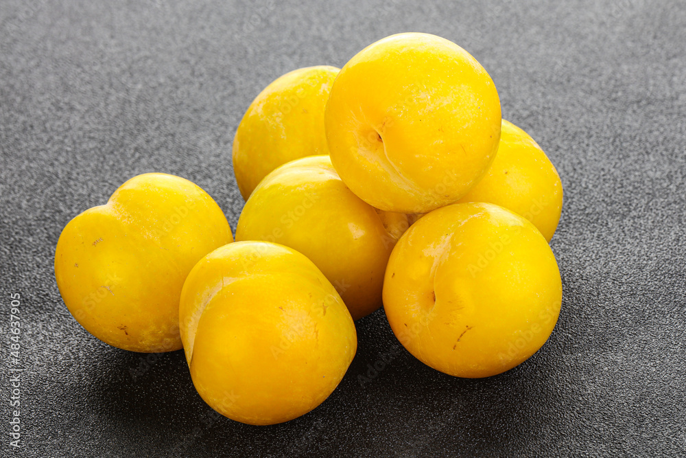 Ripe sweet yellow plum heap over background Ripe sweet yellow plum heap over background