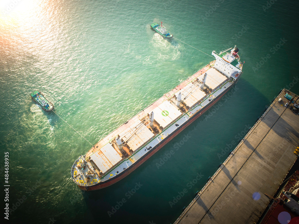 The large cargo bulk carrier vessel in the condition of sailing from the sea port terminal to the middle of the sea, navigating lead by master captain pilot officer, heading to next port destination 