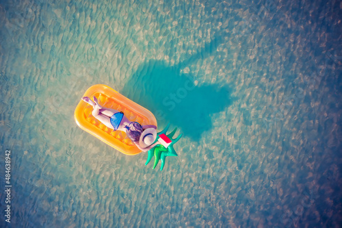 .woman in bikini enjoy swimming on inflatable tube at the sea island, summertime enjoyment in the sea alone, weekend and vacation enjoyment in the sea summertime