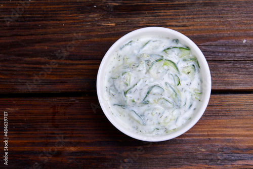 Tzatziki in a bowl. Tsatsiki top view. Traditional Greek dipping sauce or sauce tzatziki prepared with grated cucumber sour cream yogurt olive oil and fresh dill