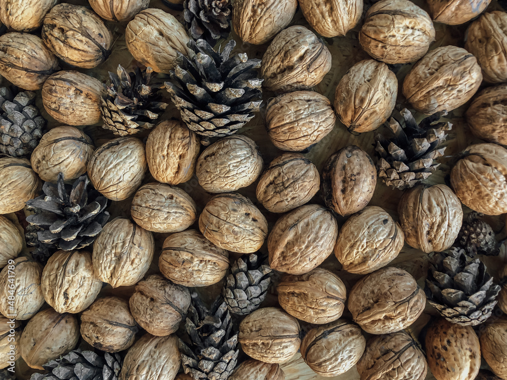 Autumn vibe background texture formed from walnuts and pine cones flat laid on table Autumn vibe background texture formed from walnuts and pine cones flat laid on table