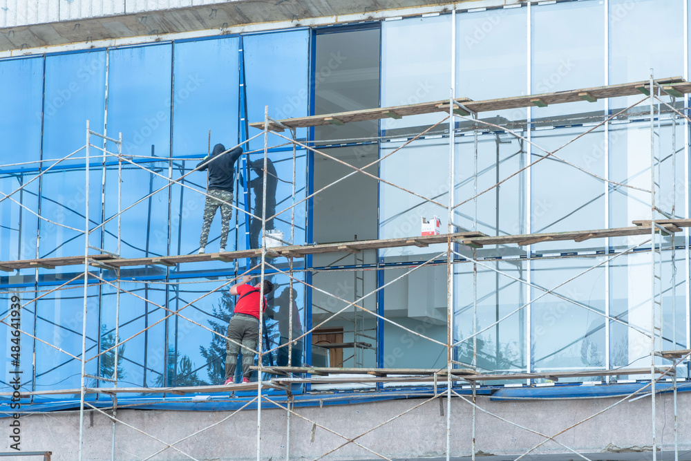 Moscow, Russia,05,10,2021:Restoration, reconstruction and repair of the building. Construction workers are standing on scaffolding at the structure.Housing Restoration Construction Site