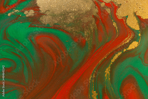 Gold spots on flow red and green paints background. Abstract print
