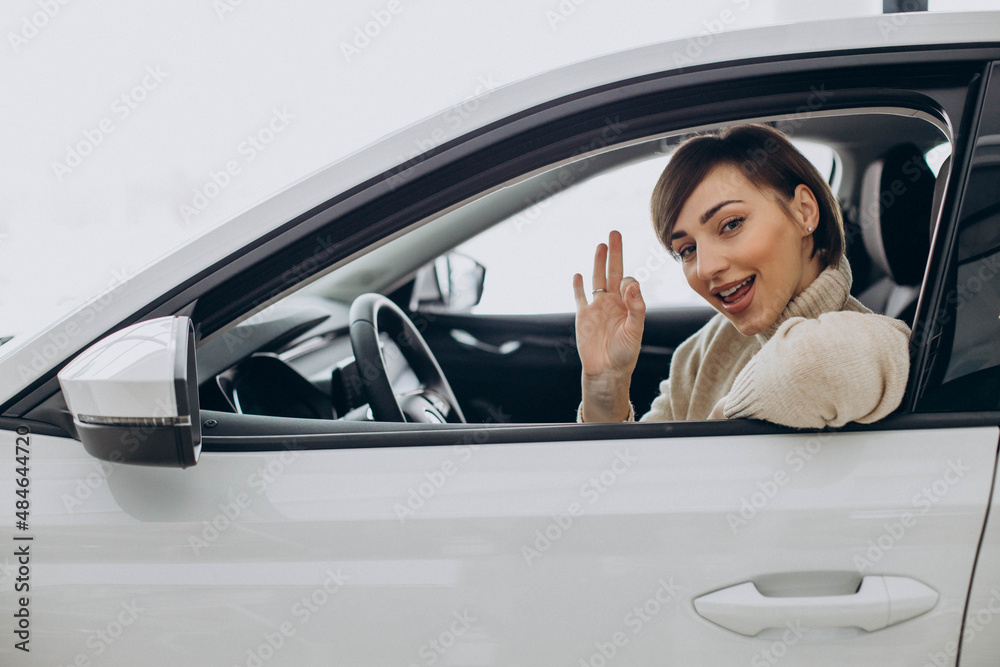 Woman sitting in car in a car showroom