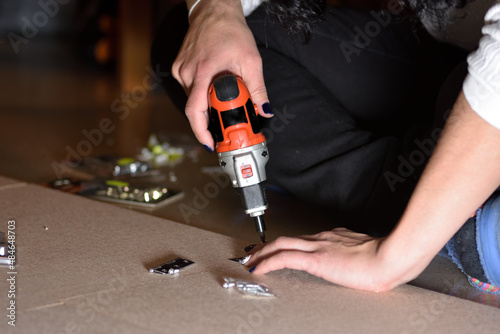 photograph of a hands of a woman with painted nails, doing some DIY at home. selective focus
