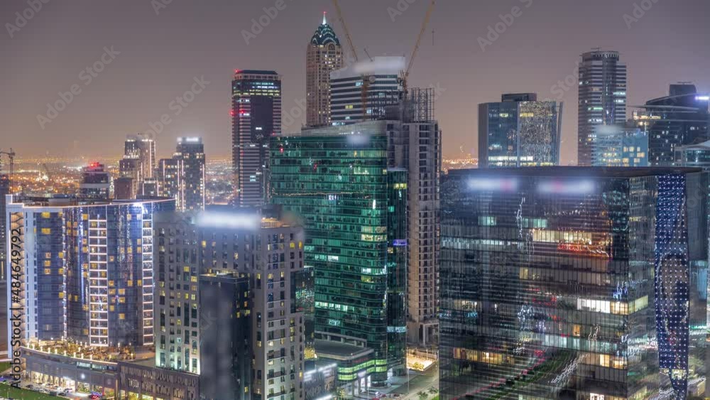 Business Bay Dubai skyscrapers with city lights reflected on glass aerial night timelapse. Business Bay Dubai skyscrapers with city lights reflected on glass aerial night timelapse.
