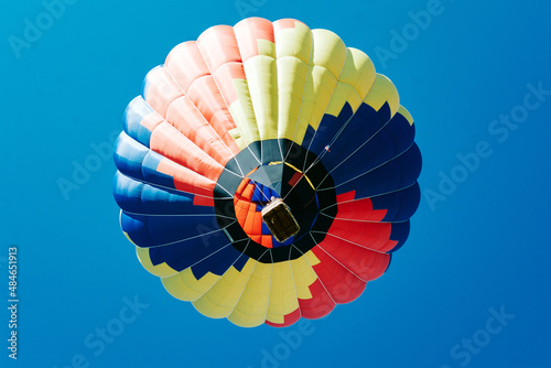 Multicolored hot air balloon on blue sky close up horisontal