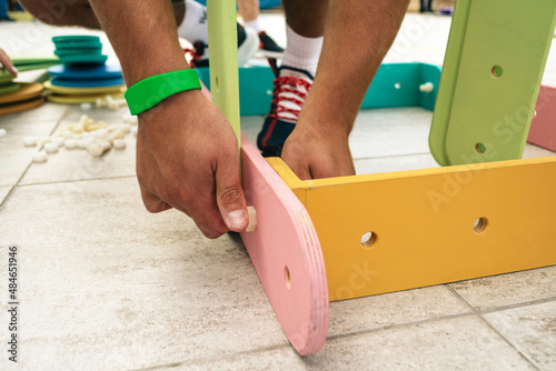 A man assembles a wooden construction set in a team game
