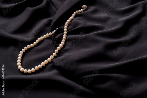 Pearl necklace on black silk.