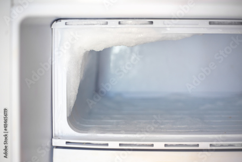 Fridge freezer with frozen ice. Maintenance and defrosting of the refrigerator photo