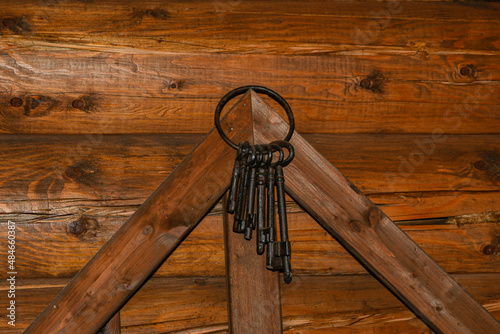 Bunch of vintage metal keys. Keys hang on a wooden wall. 