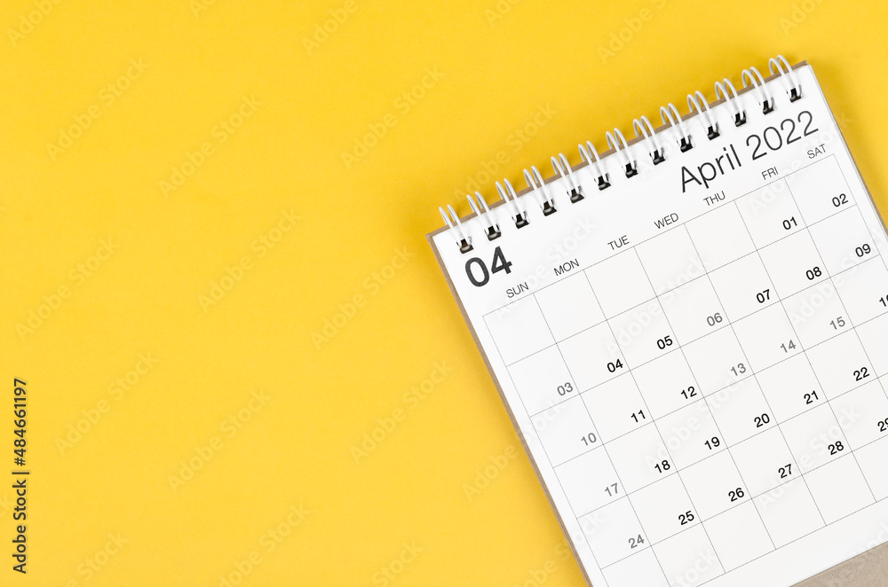 April 2022 desk calendar on yellow background with empty space. April 2022 desk calendar on yellow background with empty space.
