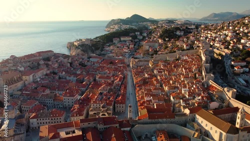 Amazing panoramic sunset drone view of old city of Dubrovnik, Croatia. View of the historical center and main street named Stradun in the sunset rays. photo