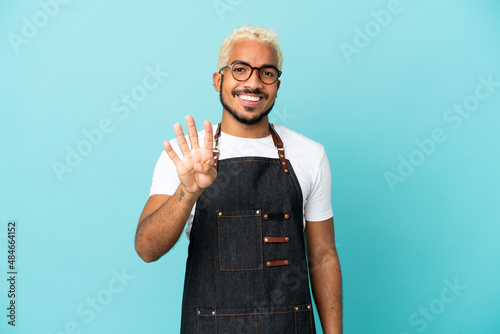 Restaurant Colombian waiter man isolated on blue background happy and counting four with fingers