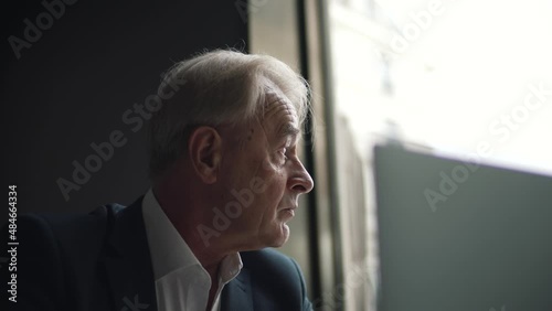 elderly businessman looking out the window