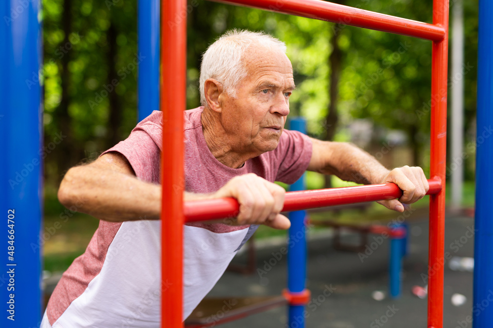 Obraz premium Sportive elderly man training on outdoor sports ground