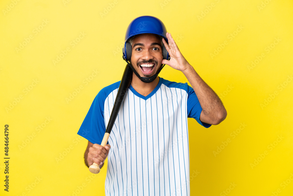 Young Colombian latin man playing baseball isolated on yellow background with surprise expression