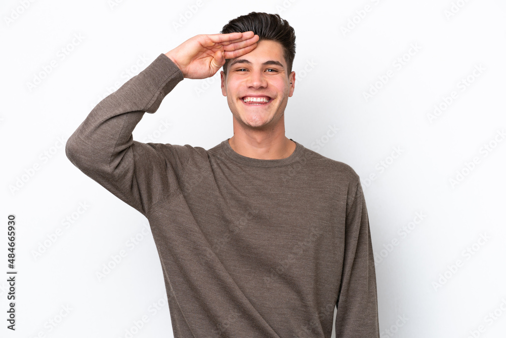 Young handsome caucasian man isolated on white bakcground saluting with hand with happy expression Young handsome caucasian man isolated on white bakcground saluting with hand with happy expression