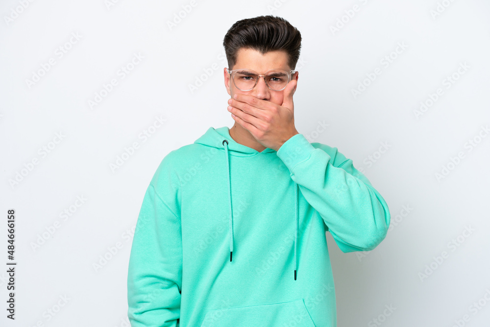 Young handsome caucasian man isolated on white bakcground covering mouth with hand Young handsome caucasian man isolated on white bakcground covering mouth with hand