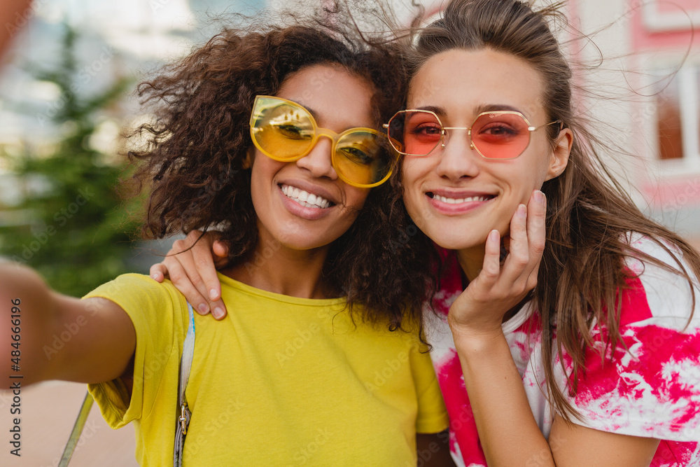 happy young girls friends smiling sitting in street