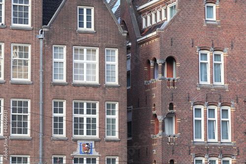 Amsterdam Damrak Street Brick Building Facades Close Up with Stone Tablet Depicting a Red Chicken, Netherlands