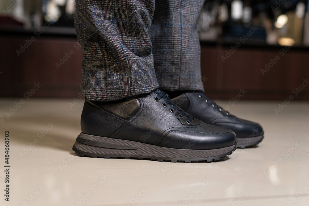 men's black leather sneakers worn on the foot men's black leather sneakers worn on the foot