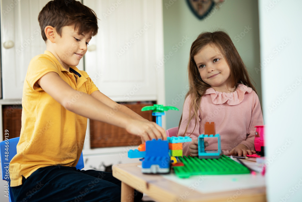 SIster and brother playing with toys at home. Little childs playing with lots of toys indoor. SIster and brother playing with toys at home. Little childs playing with lots of toys indoor.