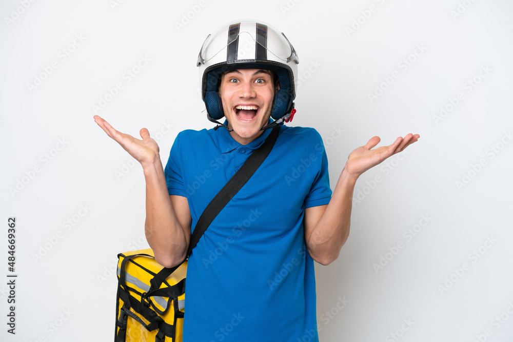 Young caucasian man with thermal backpack isolated on white background with shocked facial expression Young caucasian man with thermal backpack isolated on white background with shocked facial expression