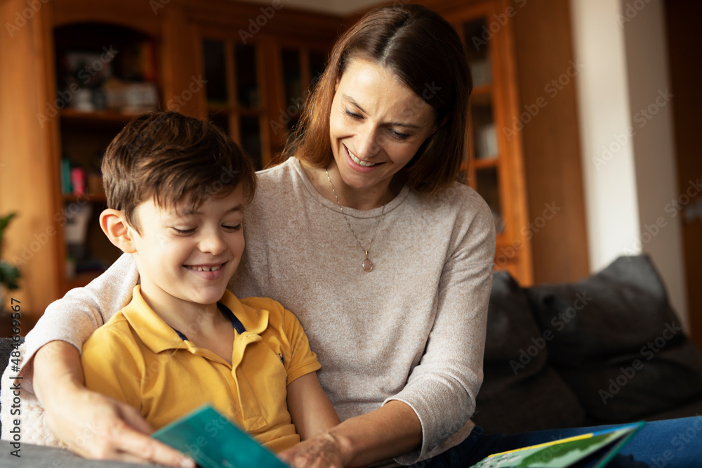 Obraz premium Mother and son reading a book. Little boy enjoy with mom reading a book