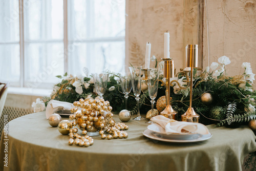 Foto table set for Christmas or New Year's dinner with candles, ornaments, tablecloth