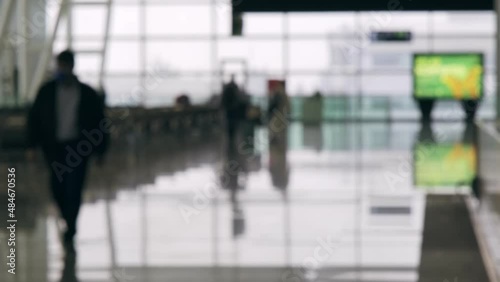 Defocused people walking at the airport with their luggage and backpacks photo