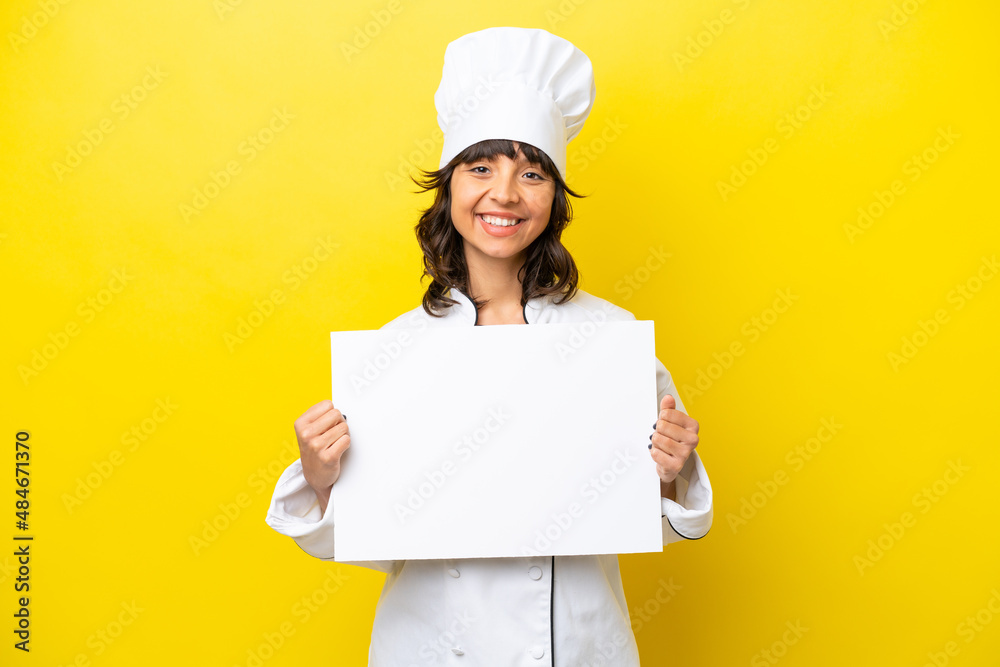 Young chef latin woman isolated on yellow background holding an empty placard with happy expression Young chef latin woman isolated on yellow background holding an empty placard with happy expression