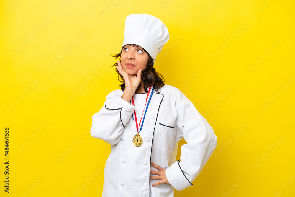 Young chef latin woman isolated on yellow background Young chef latin woman isolated on yellow background