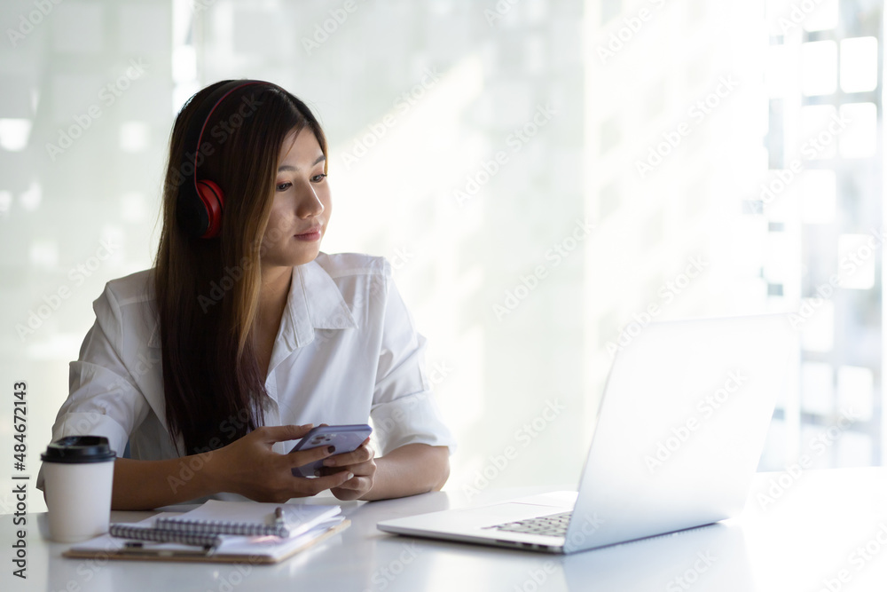 Woman working on laptop in white office in the morning. Woman looking at laptop screen having online meeting and studying online. Woman working on laptop in white office in the morning. Woman looking at laptop screen having online meeting and studying online.