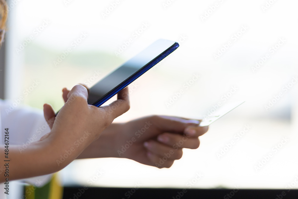 Hand holding credit card and using mobile phone. Hand holding credit card and using mobile phone.