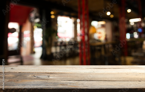 Empty dark wooden table in front of abstract blurred bokeh background of restaurant . can be used for display or montage your products.Mock up for space © kishivan