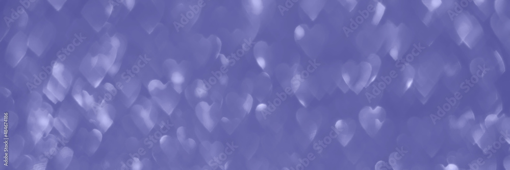 Trendy very peri color of the year 2022, violet hearts bokeh background texture. Holiday valentines day lights. Abstract defocused header. Panoramic web banner with copy space for design
