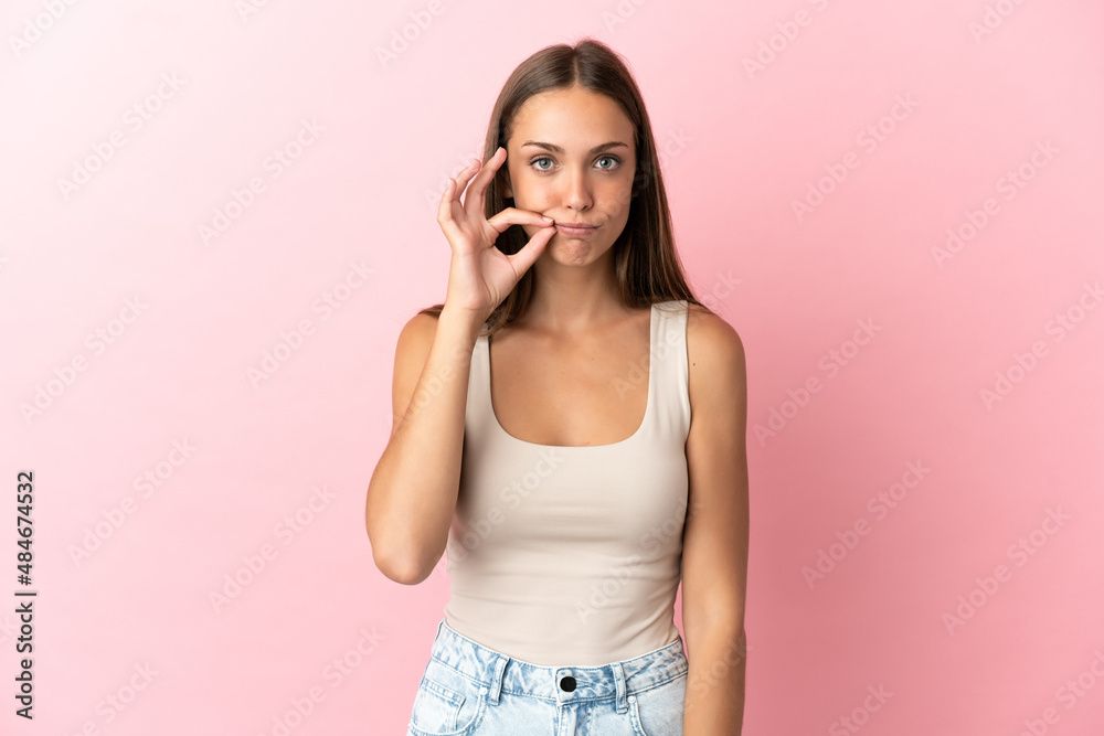 Young woman over isolated pink background showing a sign of silence gesture Young woman over isolated pink background showing a sign of silence gesture