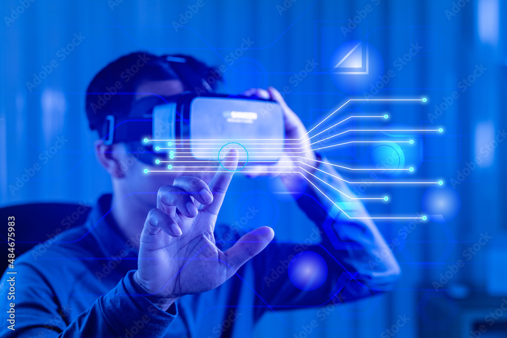 A man Wearing Virtual Reality Headset Sitting in a Chair Using Futuristic Holographic Interface. Modern data Study Neurological Research Center, future technology concept. A man Wearing Virtual Reality Headset Sitting in a Chair Using Futuristic Holographic Interface. Modern data Study Neurological Research Center, future technology concept.