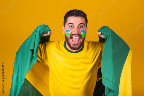 Brazilian man, latin american, cheering for brazil, in world cup 2022, Patriot, nationalist, Vibrating brazil flag, cheering and jumping, symbol of happiness, joy and celebration, with brazil flag photo