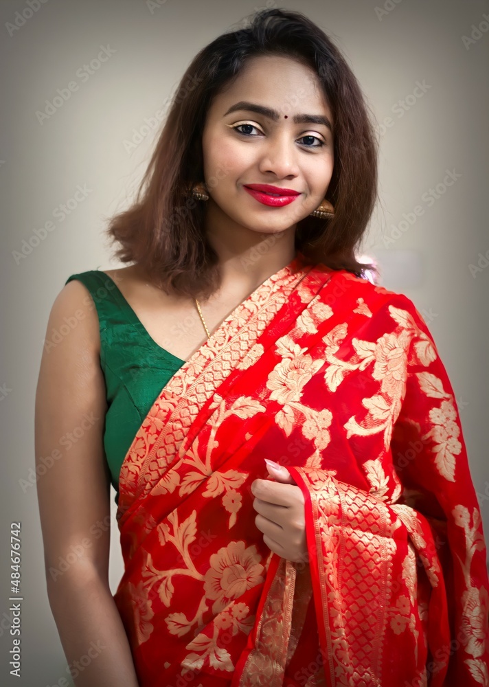 Fashion photoshoot indoors - portrait of an Indian female model wearing a red Indian saree Fashion photoshoot indoors - portrait of an Indian female model wearing a red Indian saree
