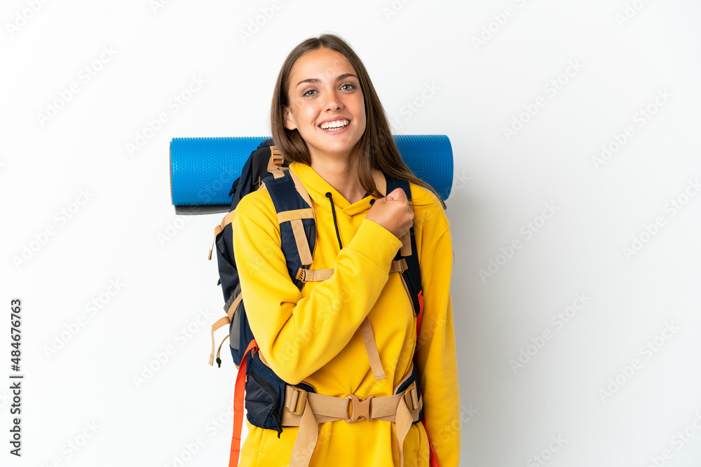 Young mountaineer woman with a big backpack over isolated white background celebrating a victory Young mountaineer woman with a big backpack over isolated white background celebrating a victory