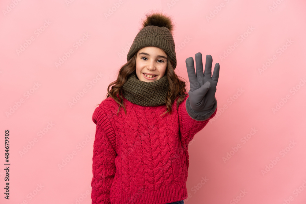 Little girl with winter hat isolated on pink background happy and counting four with fingers Little girl with winter hat isolated on pink background happy and counting four with fingers