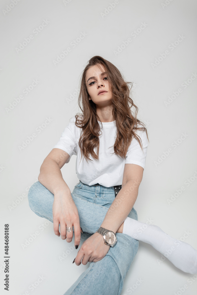 Pretty woman in fashion casual denim clothes sits in studio Pretty woman in fashion casual denim clothes sits in studio