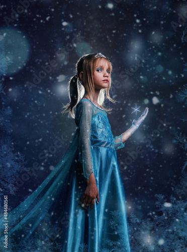 Young girl snow princess. Mystery fantasy girl in blue lush dress. Art background winter frozen and snow.