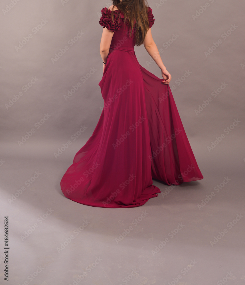 Obraz premium TIMISOARA, ROMANIA - April 26, 2018: brunette woman wearing a red long dress is having a studio photo shooting